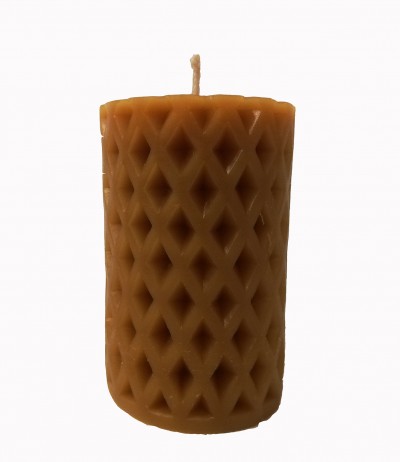 Vela cilíndrica castanho claro com padrão em relevo de losangos e pavio no topo