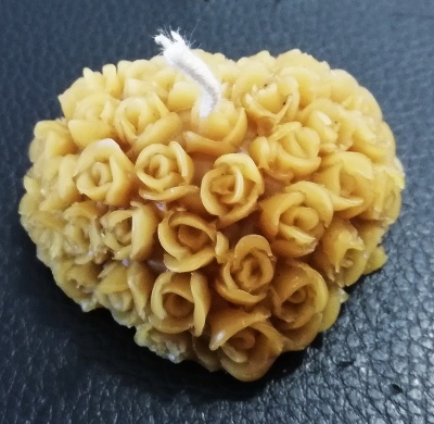 vela amarela em forma de coração com pequenas flores detalhadas