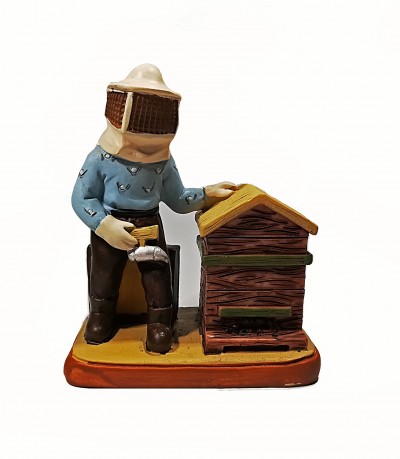 Figura decorativa de apicultor junto a colmeia