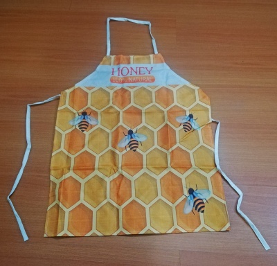Avental com padrão de favos de mel e abelhas, texto HONEY 100% NATURAL