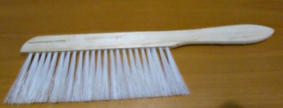 Pente de madeira com cerdas brancas sobre superfície de madeira