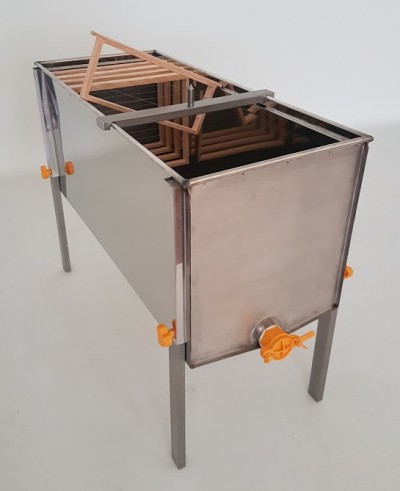 Aparelho metálico retangular com grades internas de madeira e torneira plástica laranja