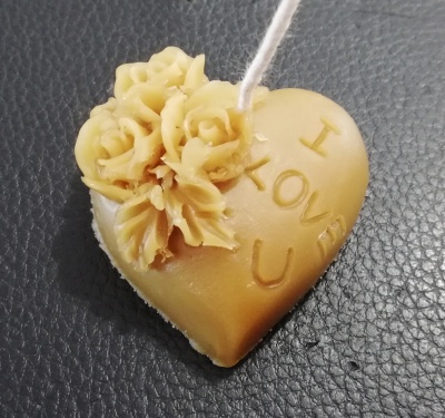 Vela amarela em forma de coração com rosas decorativas e texto I LOVE U