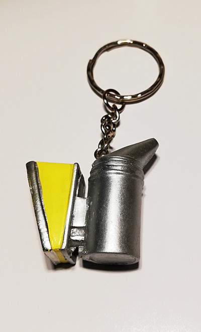 Porta-chaves em forma de fumegador com corpo prateado e tampa amarela