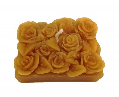 Vela amarela decorativa com rosas esculturais na superfície