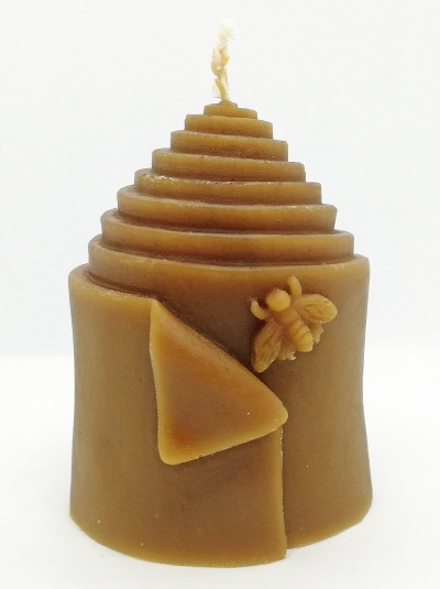 Vela castanha em forma de colmeia com abelha detalhada e cera dobrada, sobre fundo branco