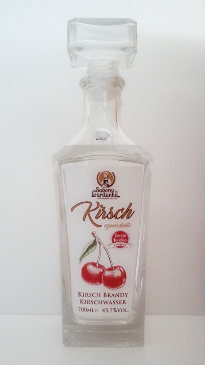 Garrafa de Kirsch aguardente com rótulo branco e cerejas vermelhas