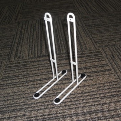 Suportes metálicos brancos com tampa preta sobre carpete castanho