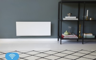 Radiador branco na parede cinzenta com prateleira preta e livros