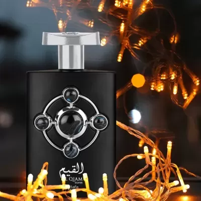 Frasco de perfume preto com design prateado e luzes decorativas amarelas