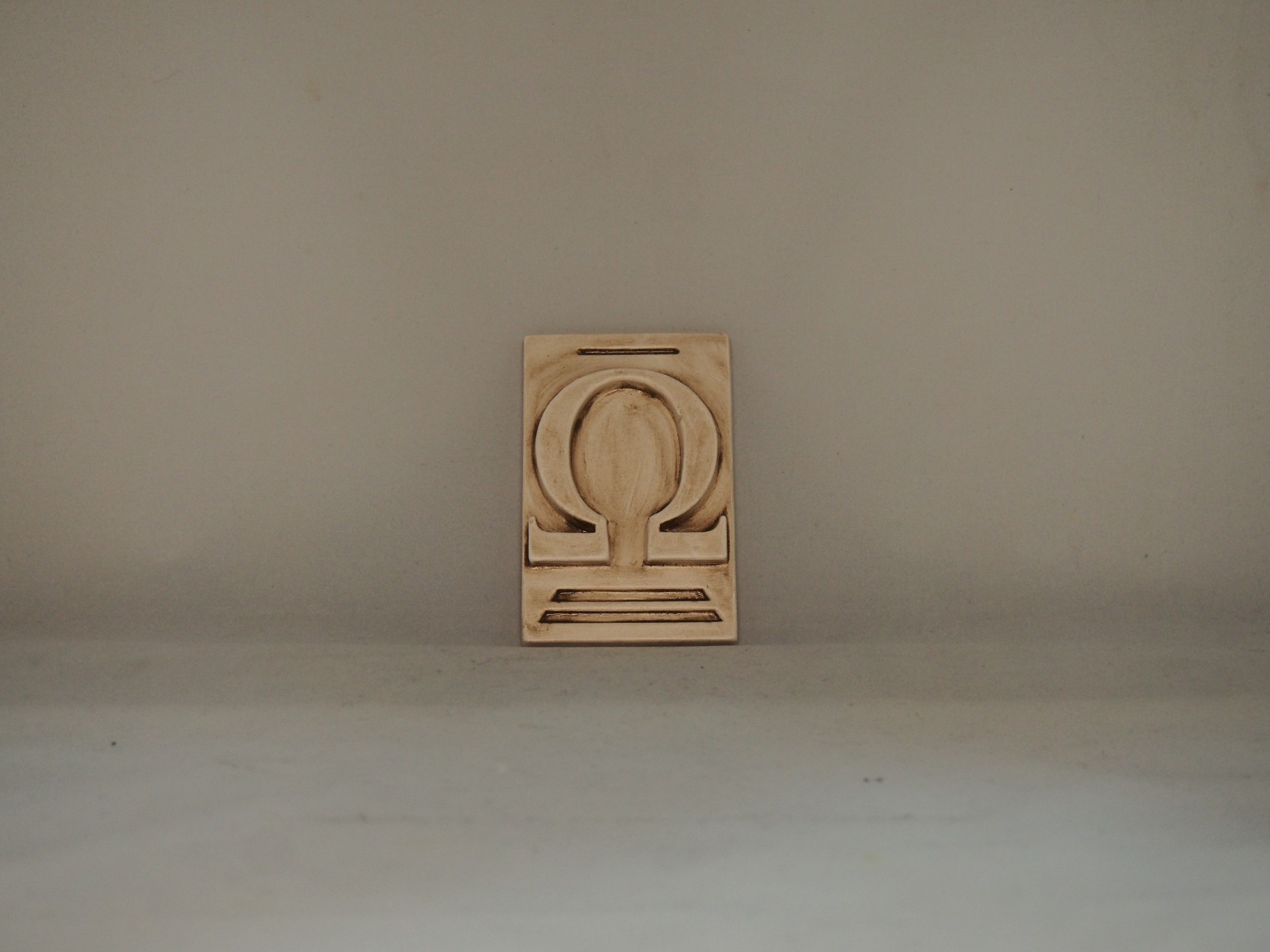 Letra "OMEGA" 10x6,5 faiança patine castanho