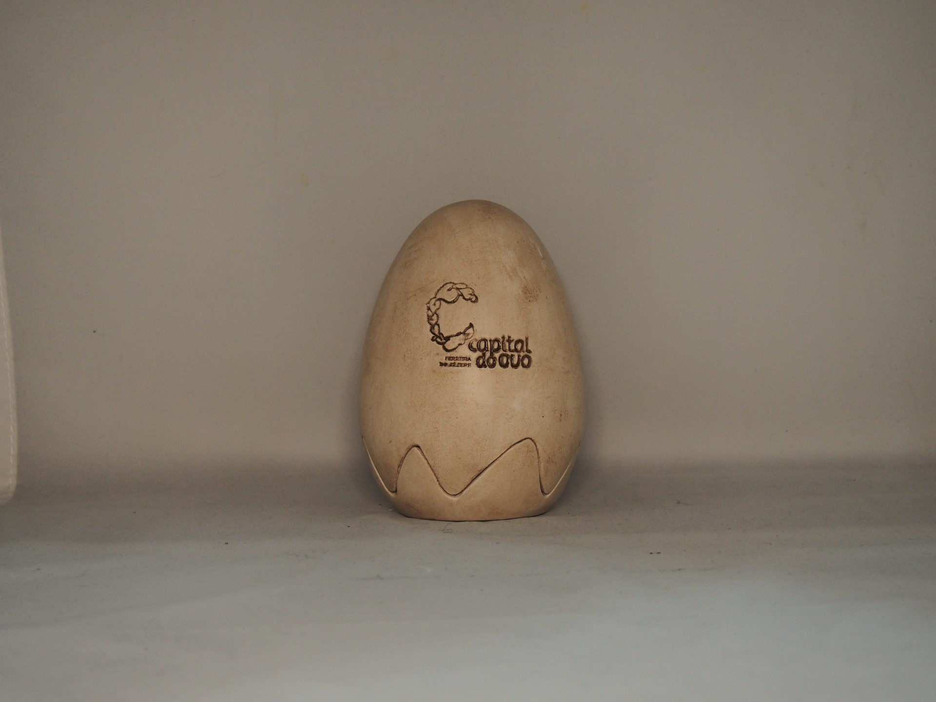 Objeto decorativo em forma de ovo com inscrição Capitel do Sul