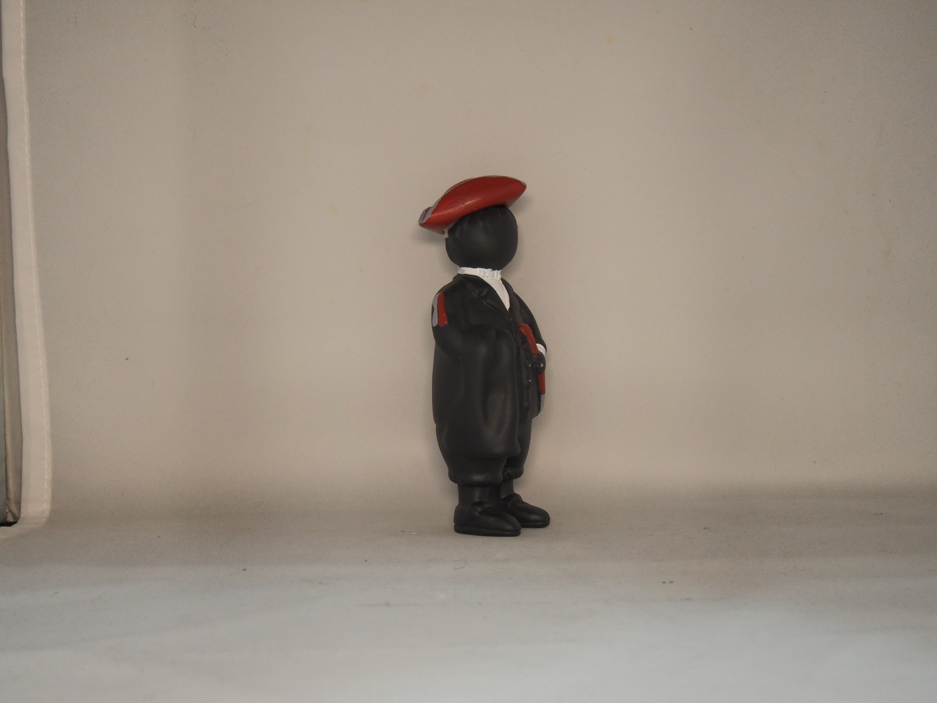 Boneco decorativo em uniforme de guarda com boina vermelha