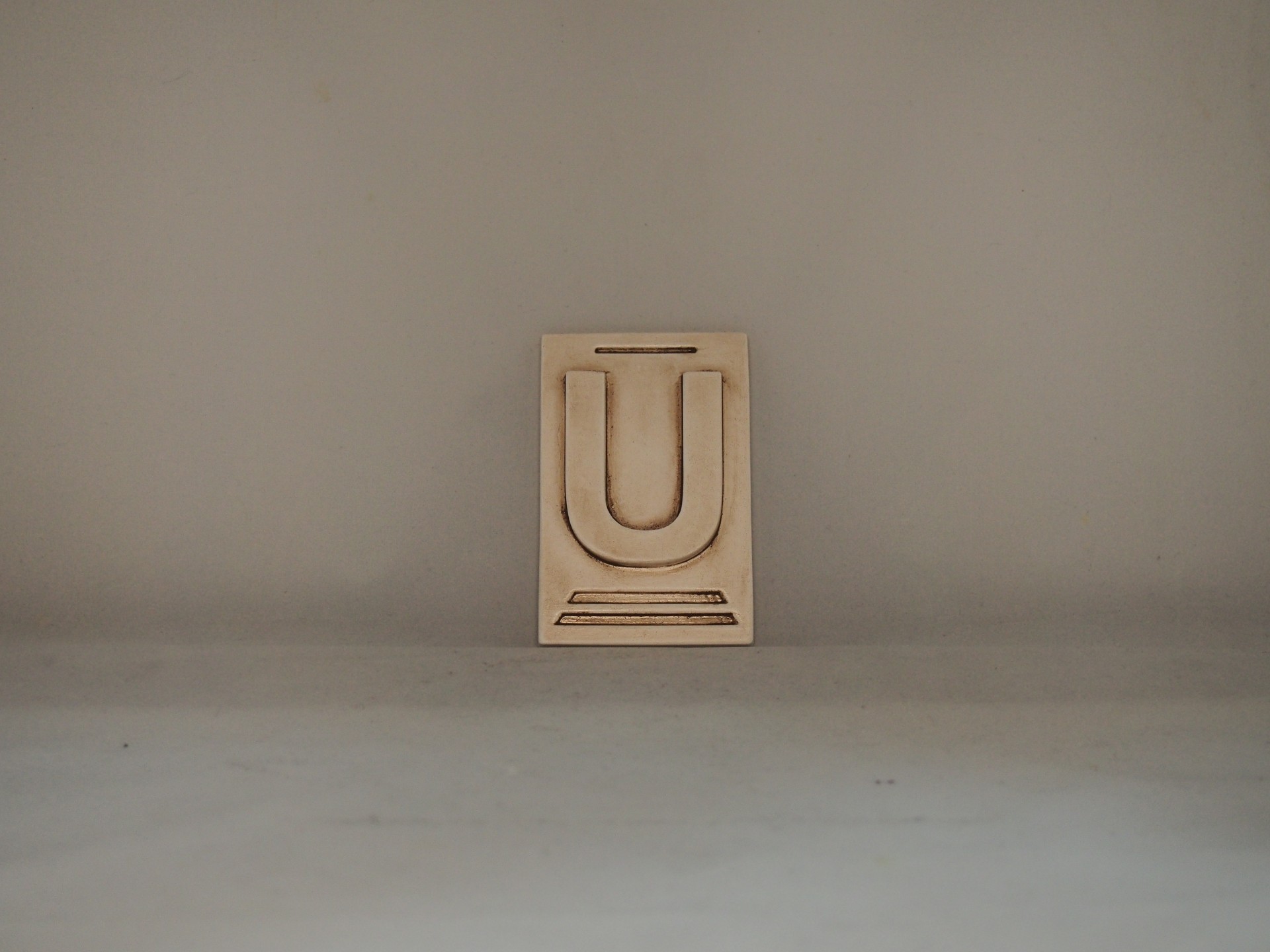 Letra U 10x6,5 faiança patine castanho