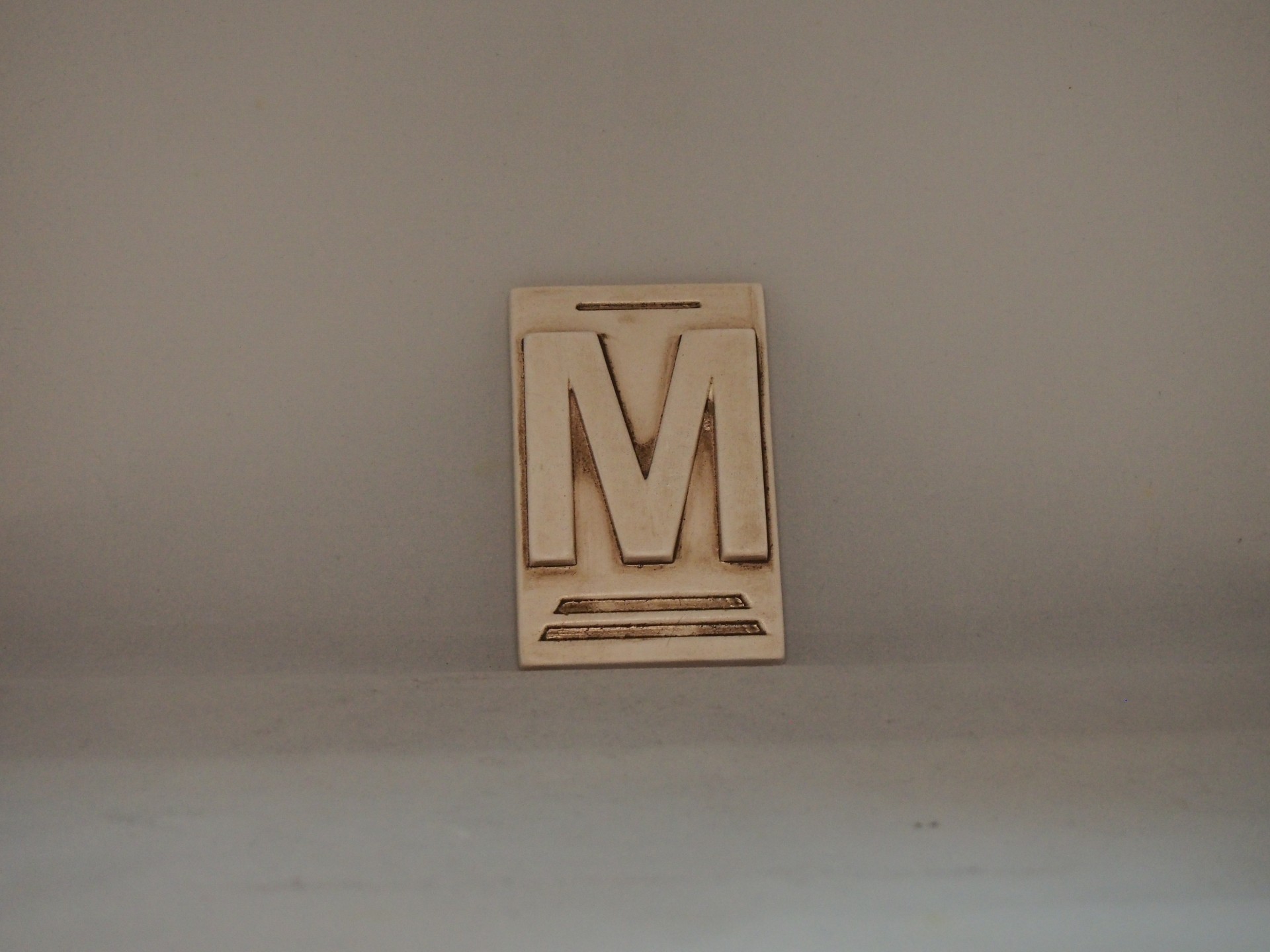 Letra M 10x6,5 faiança patine castanho