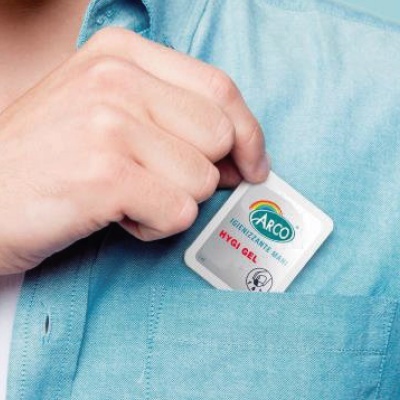 Frasco branco de gel higienizante para mãos ARCO HYGI GEL no bolso da camisa azul