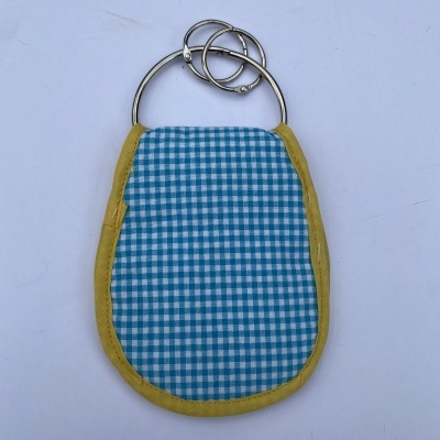 Produto têxtil azul e branco com bordado amarelo e argolas metálicas