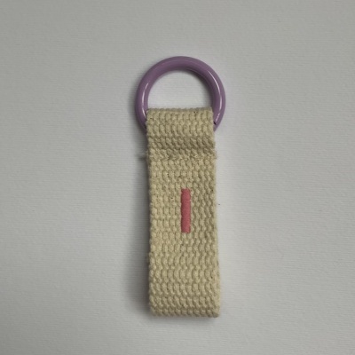 Chaveiro de tecido bege com argola roxa e detalhe vermelho