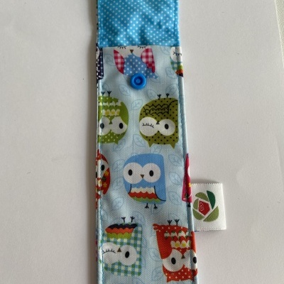 Estojo de tecido colorido com padrão de corujas e fecho de botão azul