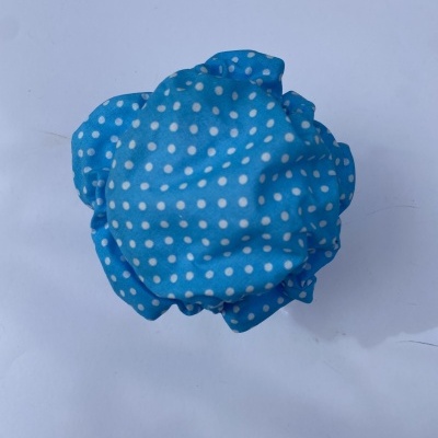 Touca de banho azul com bolinhas brancas sobre fundo branco