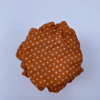 Almofada redonda laranja com estrelas brancas