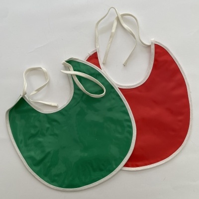 Dois babetes de bebé verde e vermelho com bordas brancas sobre fundo branco.