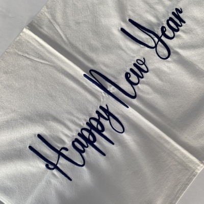 Toalha branca com texto bordado Happy New Year em azul escuro