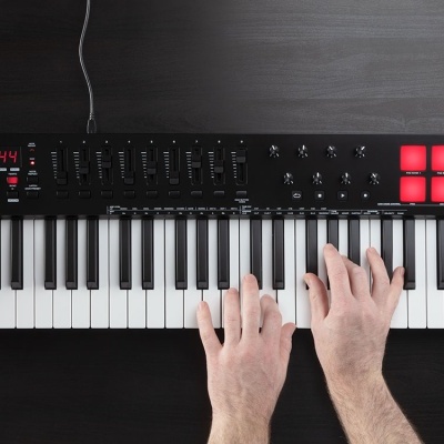 Teclado controlador MIDI preto M-AUDIO com pads vermelhos e controlos variados