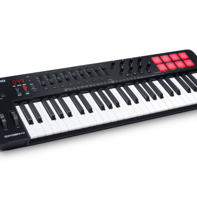 Teclado controlador MIDI preto M-AUDIO OXYGEN 49 com teclas, botões, faders e pads iluminados a vermelho