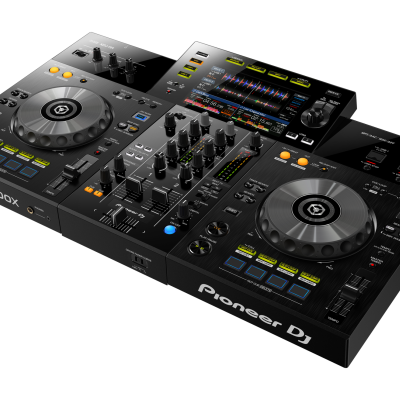 Controlador DJ preto com botões, knobs, dois pratos giratórios e ecrã colorido central.