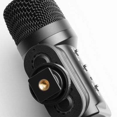 Microfone preto com grelha metálica e botão dourado sobre fundo branco