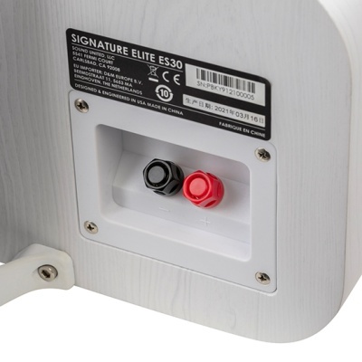 Parte traseira branca da coluna acústica com terminais de ligação e etiqueta