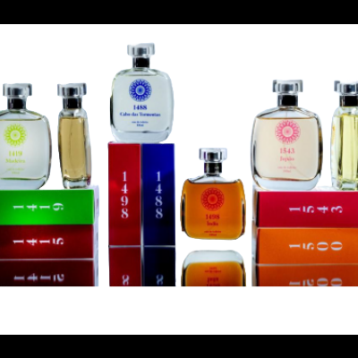 Frascos de perfume coloridos com tampas prateadas sobre caixas variadas com textos numéricos e nomes de coleções