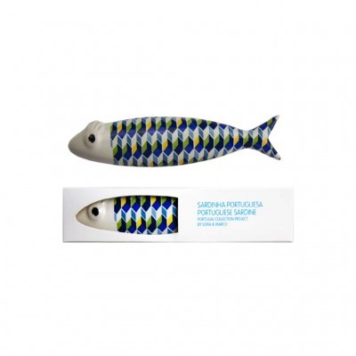 Peixe decorativo em forma de sardinha com padrão geométrico azul, verde e branco junto a uma embalagem branca com texto.