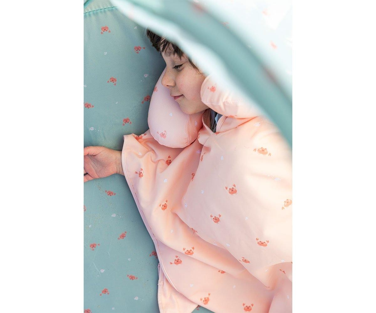 Criança a dormir com cobertor e almofada cor-de-rosa com padrão de caranguejos