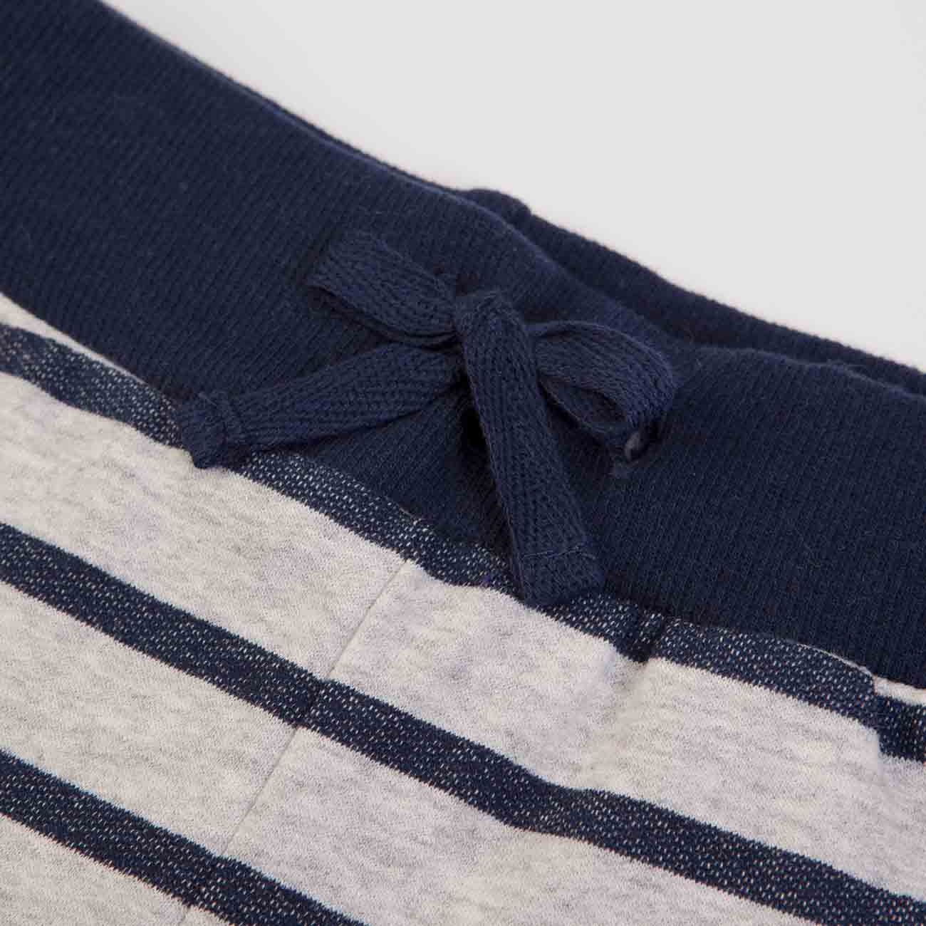 Cós azul escuro de calças com cordão de ajuste e riscas cinzento claro e azul escuro.