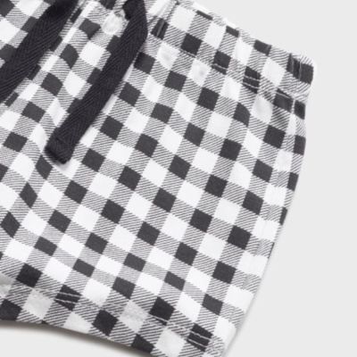 Pieza de ropa con patrón de cuadros en blanco y negro y cordón negro