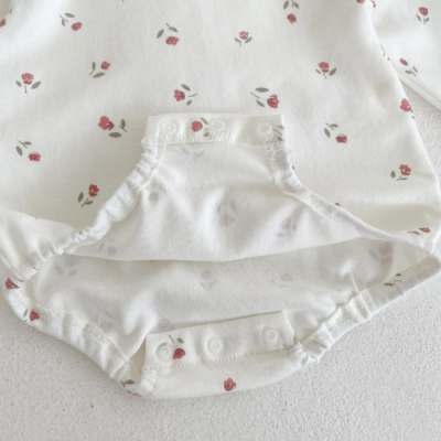 Body de bebé branco com flores vermelhas e fecho de molas.