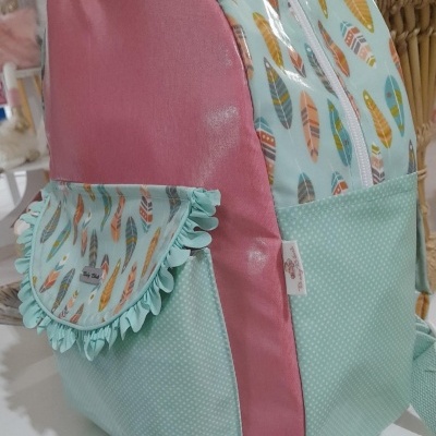 Mochila rosa, verde menta com pontos brancos e padrão de penas coloridas com bolso lateral e folhos