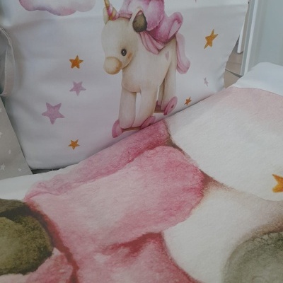 Ilustração de criança com fato de coelho montada em unicórnio sobre fundo com estrelas e nuvens