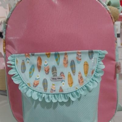 Mochila cor-de-rosa com bolso frontal azul claro com padrão de penas coloridas e etiqueta 'Baby Dahlia'