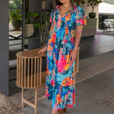 Mulher com vestido comprido colorido num ambiente coberto