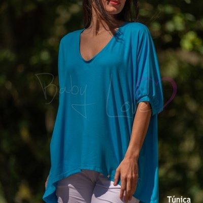 Mulher a usar túnica azul e calças brancas ao ar livre