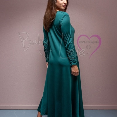 Mulher de costas com vestido verde comprido e mangas compridas