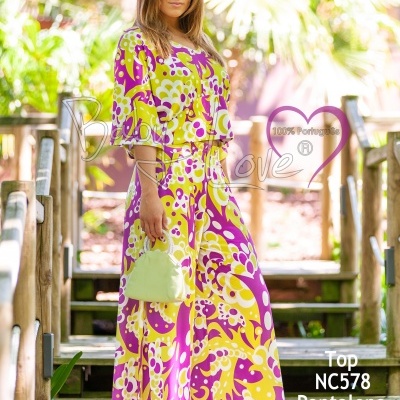 Conjunto feminino estampado em cores lilás e amarelo com top e calças largas em ambiente exterior