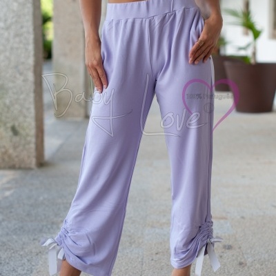 Calças lilases com detalhe franzido e fita, calçadas com sandálias transparentes