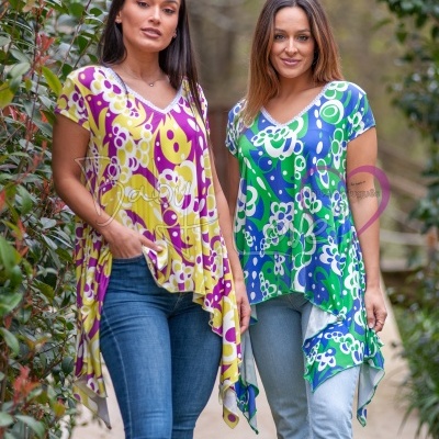 Duas mulheres com túnicas coloridas de padrão floral em ambiente ao ar livre