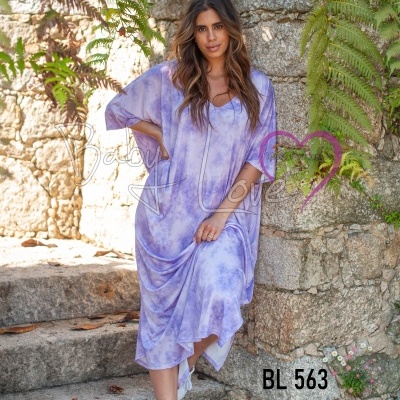 Vestido feminino maxi lilás com padrão tie-dye e ténis brancos em cenário exterior de pedra