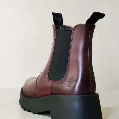 Bota tipo Chelsea castanha com sola preta grossa e elásticos laterais