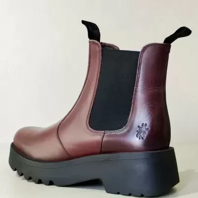 Botim Chelsea em pele castanha com sola preta grossa e elásticos pretos laterais